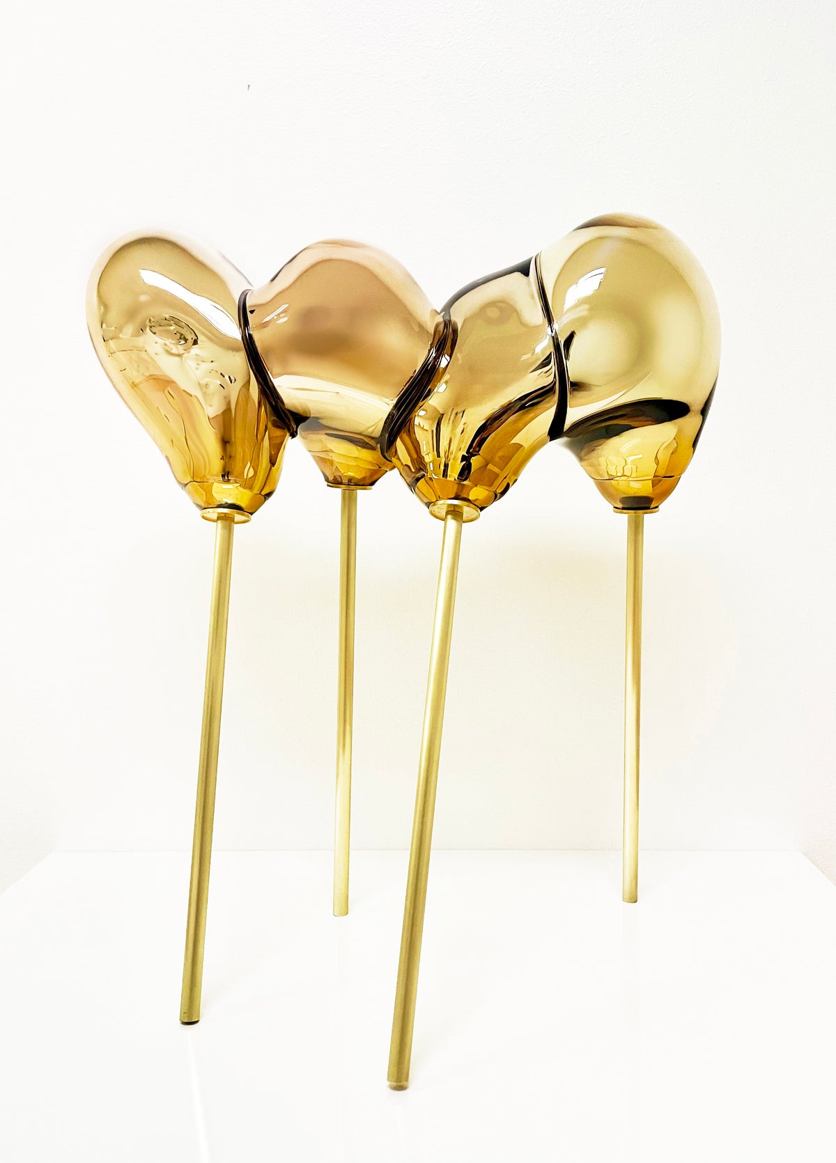 Amorphous Form in Gold by George William Bell, a reflective gold-toned glass sculpture on slender brass supports.