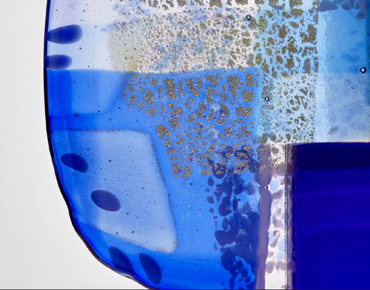 Cobalt by Amy Cushing, detail of translucent blue glass with textured inclusions and bubbles.